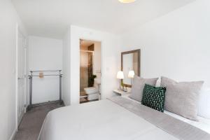 a white bedroom with a white bed and a toilet at Jasmine House in Nottingham