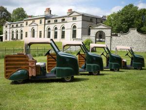three old cars parked in the grass in front of a building at Felpham Guest House - Self Catering in Bognor Regis