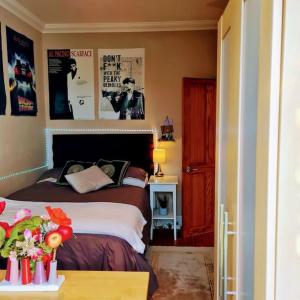 a bedroom with a bed and a table with flowers at Modern bungalow with private swimming pool in Maidenhead
