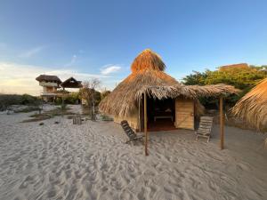 a hut on the beach with two chairs at Casa Gitana in Chamuscadero