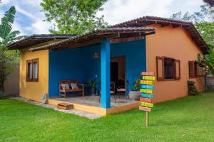 a small house with a blue and yellow exterior at Quintal de Barros in Arraial d'Ajuda