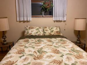 a bed in a bedroom with two lamps and a window at Grandma Sang's Bed & Breakfast 