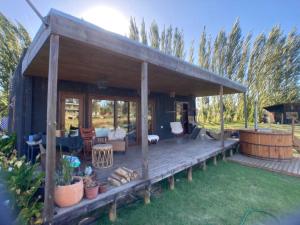 a wooden pavilion with a deck in a yard at Hermosa cabaña con hot tub. in Talagante