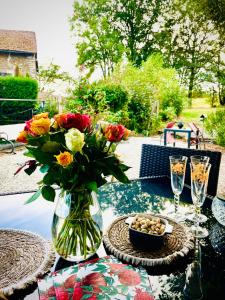 una mesa con un jarrón de flores y un tazón de huevos en Maison Des Glycines, en Droux