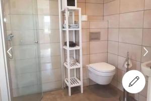a bathroom with a white toilet and a shower at Austefjorden Fjordsuite med Panoramautsikt in Forland