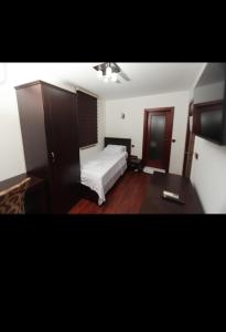 a bedroom with a white bed and a desk at Best Hotel Zambaku i Bardhe in Prizren