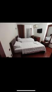 a hotel room with two beds and a television at Best Hotel Zambaku i Bardhe in Prizren