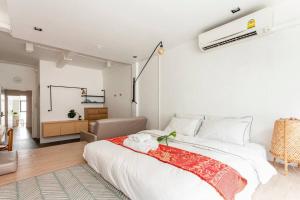 a bedroom with a large white bed and a living room at MIQ_5br/Silom Bts,Mrt/Wifi 1000MB/Jacuzzi/16pax in Bangkok