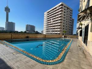 パタヤ・サウスにあるFurnished Studio Near The Beachの建物の横にある大型スイミングプール