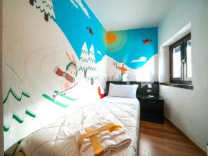 1 dormitorio con un mural de esquí en la pared en Hotel Arlecchino - Dada Hotels, en Madesimo