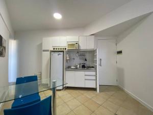 a kitchen with a glass table and a refrigerator at Vista incrível para o mar / Beautiful ocean view in Salvador