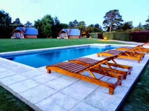 a couple of lounge chairs next to a swimming pool at Solar de las Sierras in Sierra de la Ventana