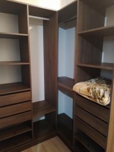 a closet with wooden shelves and a bed in it at Departamento acogedor y moderno in Cochabamba
