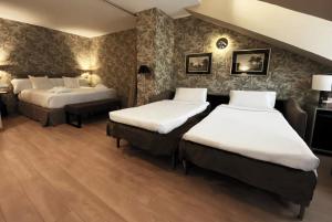 a hotel room with two beds and two tables at Hotel Meninas - Boutique Opera in Madrid