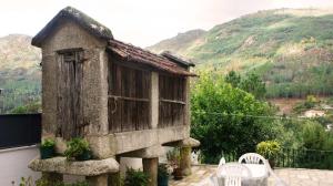a small house on a balcony with a table and chairs at Casa da Igreja by Gerês Casas in Geres