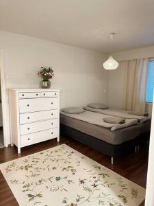 a bedroom with a bed and a dresser and a window at 2 bedroom apartment near by Santa Claus village in Rovaniemi