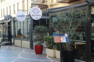 a store with potted plants in front of a street at Solo Hotel in Baku