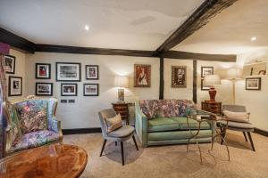 sala de estar con sofá, sillas y mesa en The George Hotel, Dorchester-on-Thames, Oxfordshire en Dorchester on thames