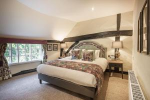 Un dormitorio con una cama grande y una ventana en The George Hotel, Dorchester-on-Thames, Oxfordshire, en Dorchester on thames
