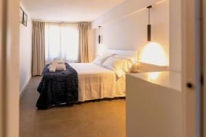 a bedroom with a bed and a window and a lamp at Suitur beachfront apartment Roc de Sant Gaietà in Roda de Bará