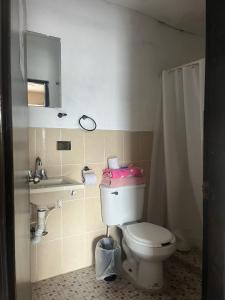een badkamer met een toilet, een wastafel en een spiegel bij LOSSANTOS in Matamoros