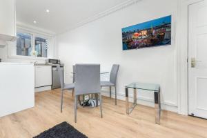 une cuisine avec une table, deux chaises, une table et une table dans l'établissement 2 Bed Piccadilly Apartment- 4, à Londres