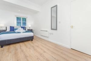 a white bedroom with a bed and a mirror at 2 Bed Piccadilly Apartment- 4 in London