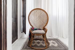 una sedia di vimini seduta su un tappeto in una stanza di Authentic Seafront Experience a Sliema