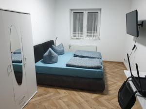 um quarto com uma cama com lençóis azuis e um espelho em City Pension Spremberg em Spremberg