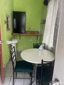 une table et des chaises blanches avec un lavabo et une télévision dans l'établissement LOSSANTOS, à Matamoros