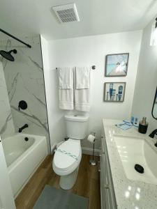 a bathroom with a toilet and a tub and a sink at Daytona Beach Club Studios! in Daytona Beach