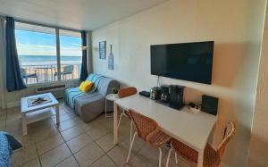 a living room with a couch and a table with chairs at Daytona Beach Club Studios! in Daytona Beach