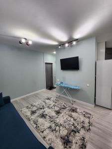 een woonkamer met een koelkast en een tapijt bij Улица Мирзо Улугбек дом 75, кв 125 in Yalanghoch