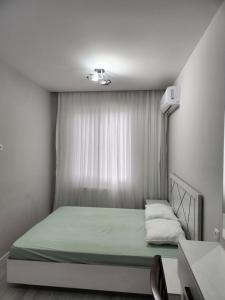 een kleine slaapkamer met een groen bed en een raam bij Улица Мирзо Улугбек дом 75, кв 125 in Yalanghoch