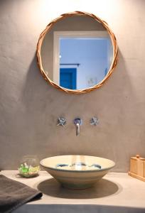 a bathroom with a bowl sink and a mirror at Keablue in Melissaki