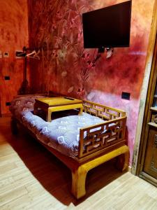 un letto in legno in una camera con TV a parete di Villa Vietnamonamour a Milano