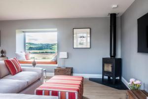 a living room with a couch and a fireplace at Luxury Couple's Retreat with Hot Tub at Lindores in Newburgh