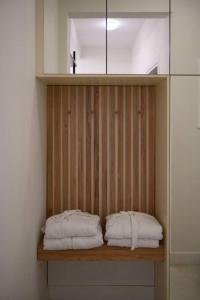 San Rocco Suite في Ágios Rókkos: منشفتان جالستان على رف خشبي في حمام