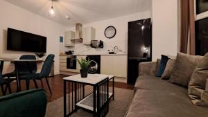 AT Evita Suites في كارديف: غرفة معيشة مع أريكة وطاولة