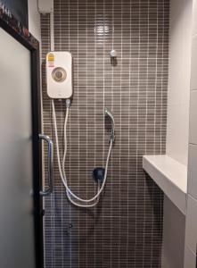 La salle de bains est pourvue d'une douche et d'un tuyau sur le mur. dans l'établissement Old Town- mimi cozy studio *70 SQM good for family, à Bangkok