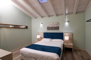 Villa Pedergnano的住宿－HILL COLLE - camere & bistrot，一间卧室配有一张大床和两盏灯。