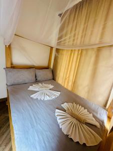 2 almohadas en una cama en una tienda en Golden hour tiny house en Arusha