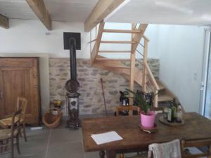 Zimmer mit einem Holztisch und einer Wendeltreppe in der Unterkunft Le gîte du Grangeon Bugiste à Argis 