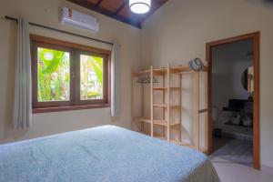 a bedroom with a bed and a window at Quintal de Barros in Arraial d'Ajuda +44 photos