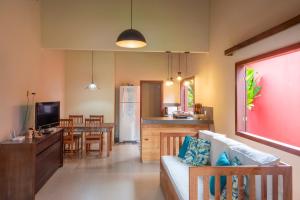 a living room with a couch and a dining room at Quintal de Barros in Arraial d'Ajuda