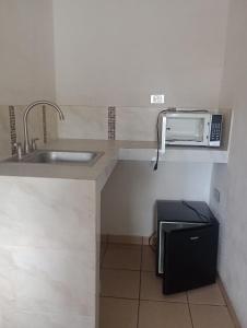 a small kitchen with a sink and a microwave at LOSSANTOS in Matamoros