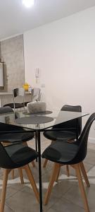een eetkamer met een glazen tafel en stoelen bij Zit Flat in Mar del Plata