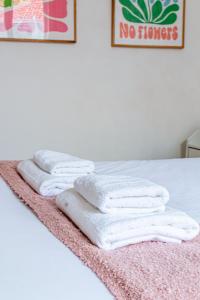 eine Reihe weißer Handtücher auf einem Bett in der Unterkunft Flat next to Montparnasse train station in Paris