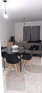 een woonkamer met een tafel, stoelen en een bed bij Zit Flat in Mar del Plata