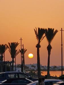 a sunset with palm trees in a parking lot at MAISON SIDI BOU SAID in Hammamet
